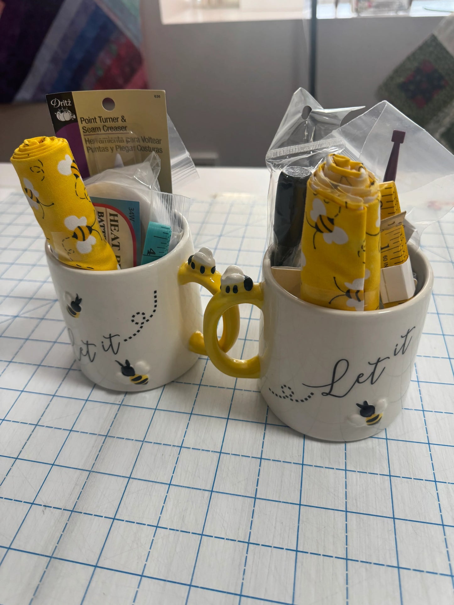 Sewer's notions mug: white ceramic with 'Let it' text, bee graphic, filled with yellow tools