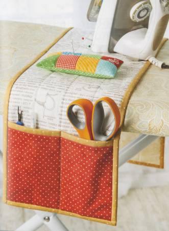 Sewing machine organizer pad with red polka-dot pockets and stitched tool holders.