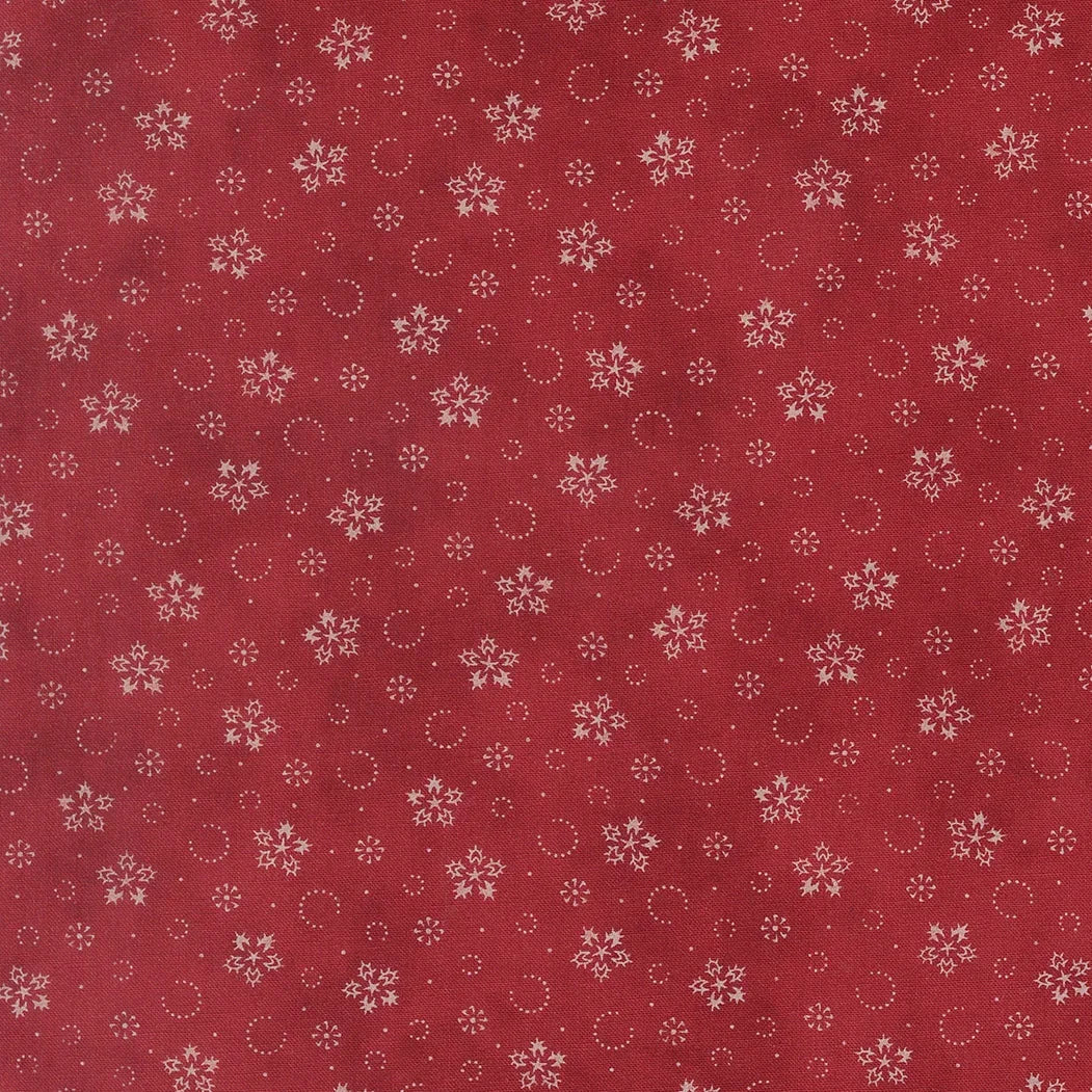 Crimson cotton fabric with scattered snowflakes and small dotted circles pattern