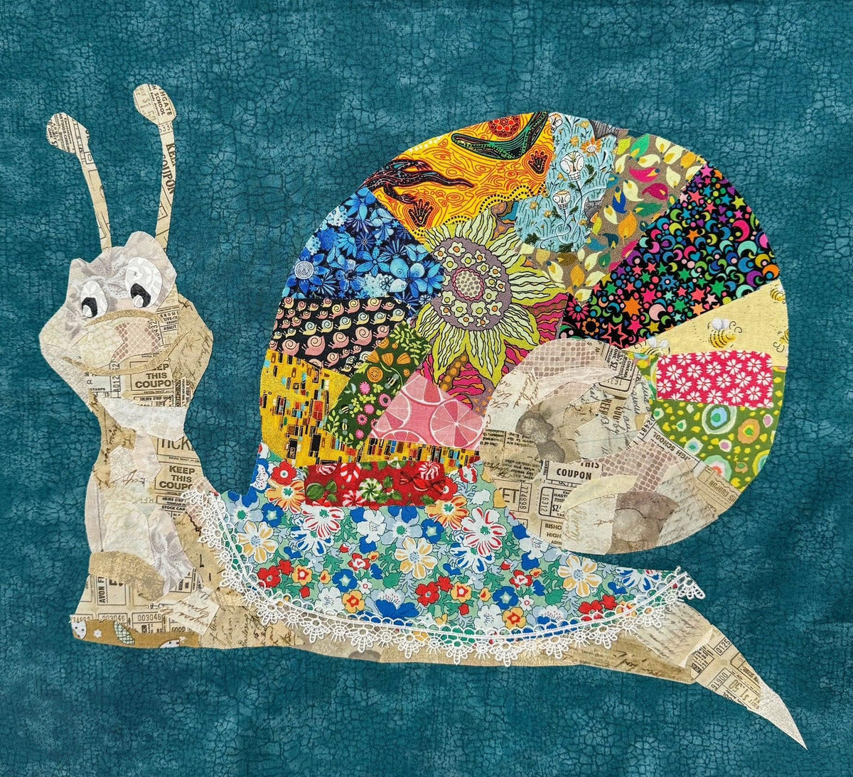 Patchwork snail collage: colorful shell, cream body, patchwork textures