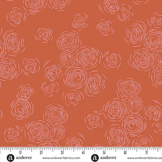 Orange fabric with repeating circular rose swirl motif in light pink
