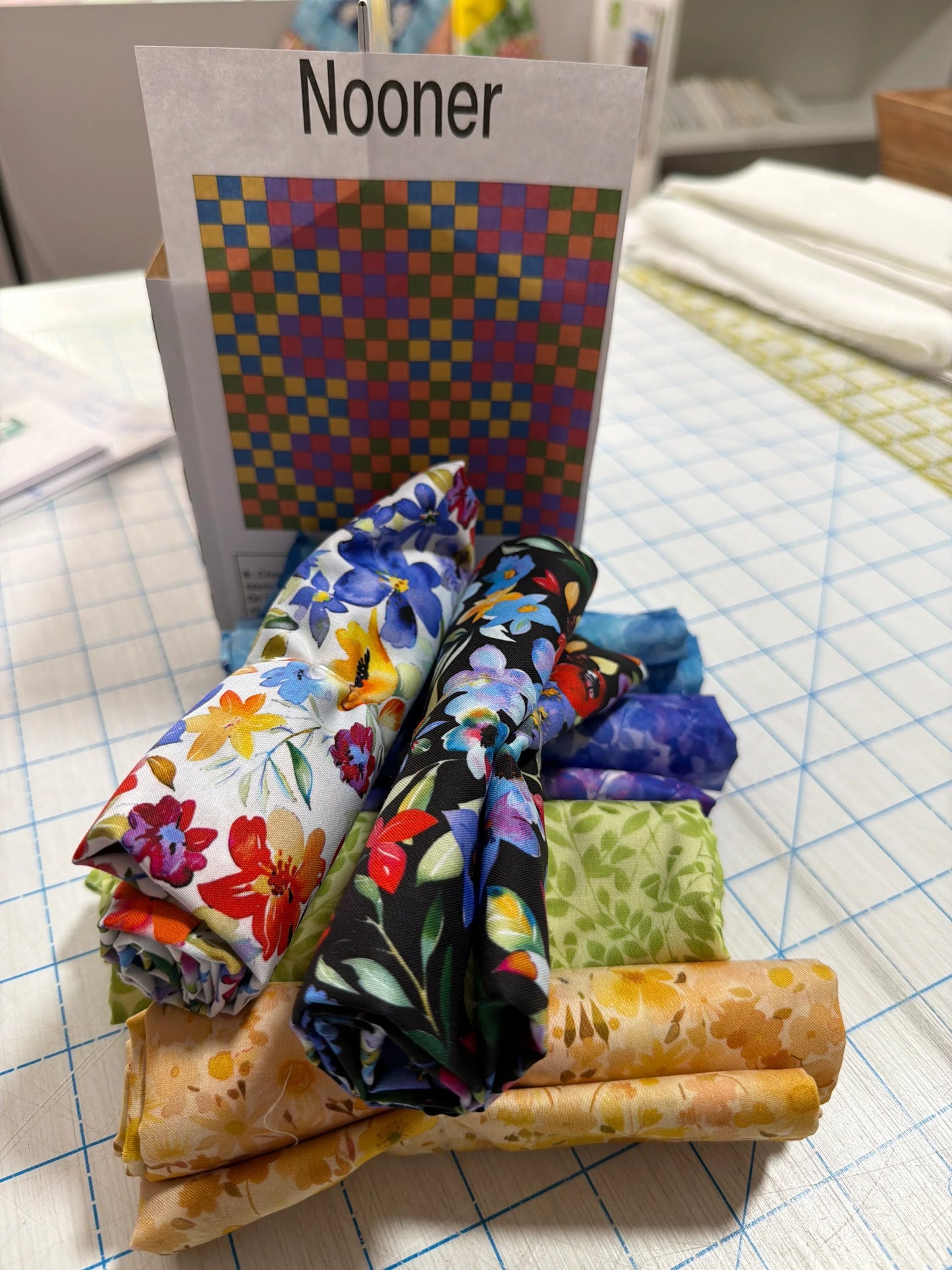 Quilt bundle with folded multicolor patchwork and floral fabric squares and strips
