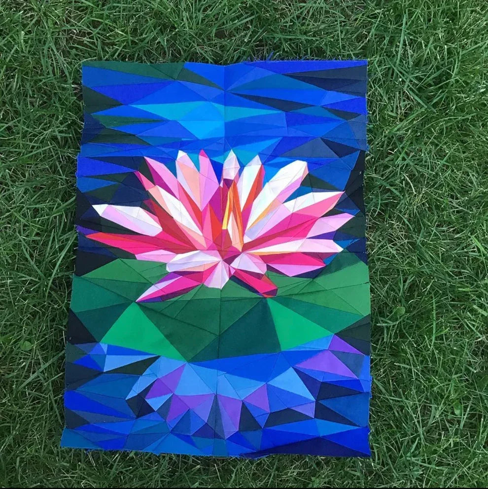 Finished geometric quilt top with lily bloom in blue, pink, and green