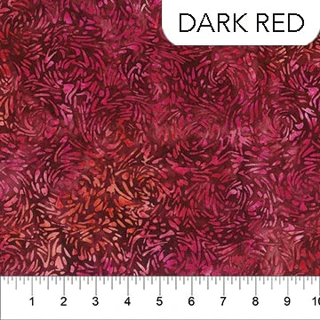 Quilting fabric in dark red with swirling leaf-like motifs and dark multicolor accents