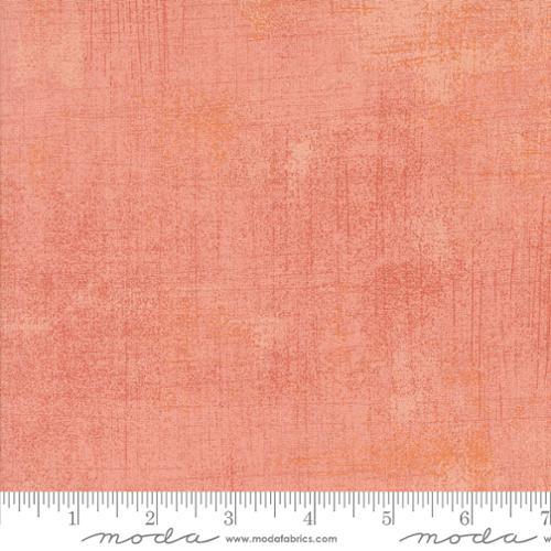 Grunge fabric swatch with mottled texture, coral pink tone