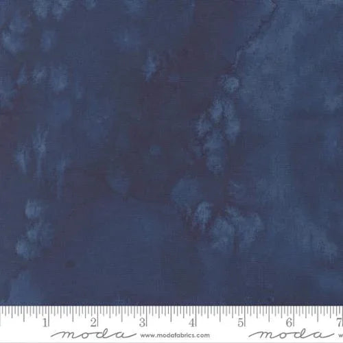 Dark blue patterned fabric with mottled small motifs, full view with measuring ruler along bottom