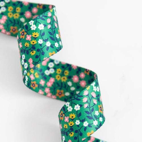 Floral patterned green fabric webbing, 1.5 inch wide, stitched edges