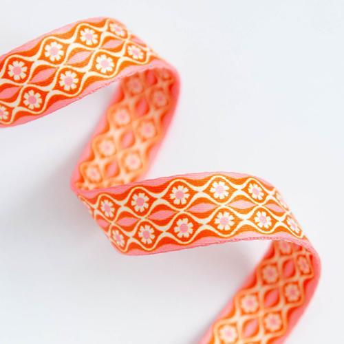 Orange fabric webbing endpaper with white floral pattern, 1 in wide