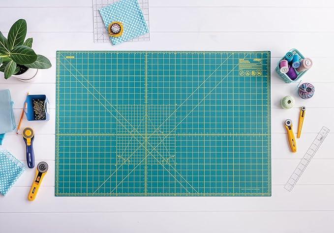 OLFA green self-healing rotary cutting mat 24x36 in with ruler grid, on work table