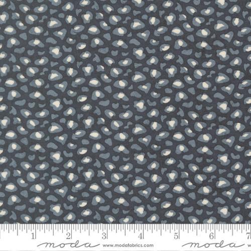 Cotton quilting fabric with small white wildflower print on dark gray-blue background