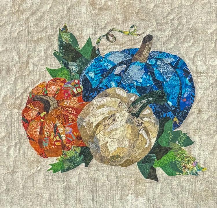 Patchwork fabric collage with blue, green, orange and beige layered fish shapes