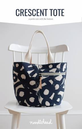 Geometric print tote bag with navy fabric and light handles, open top