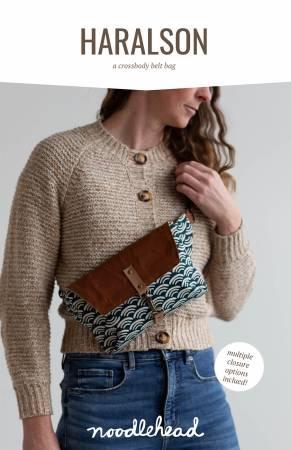 Crossbody belt bag with brown flap and blue patterned fabric panel