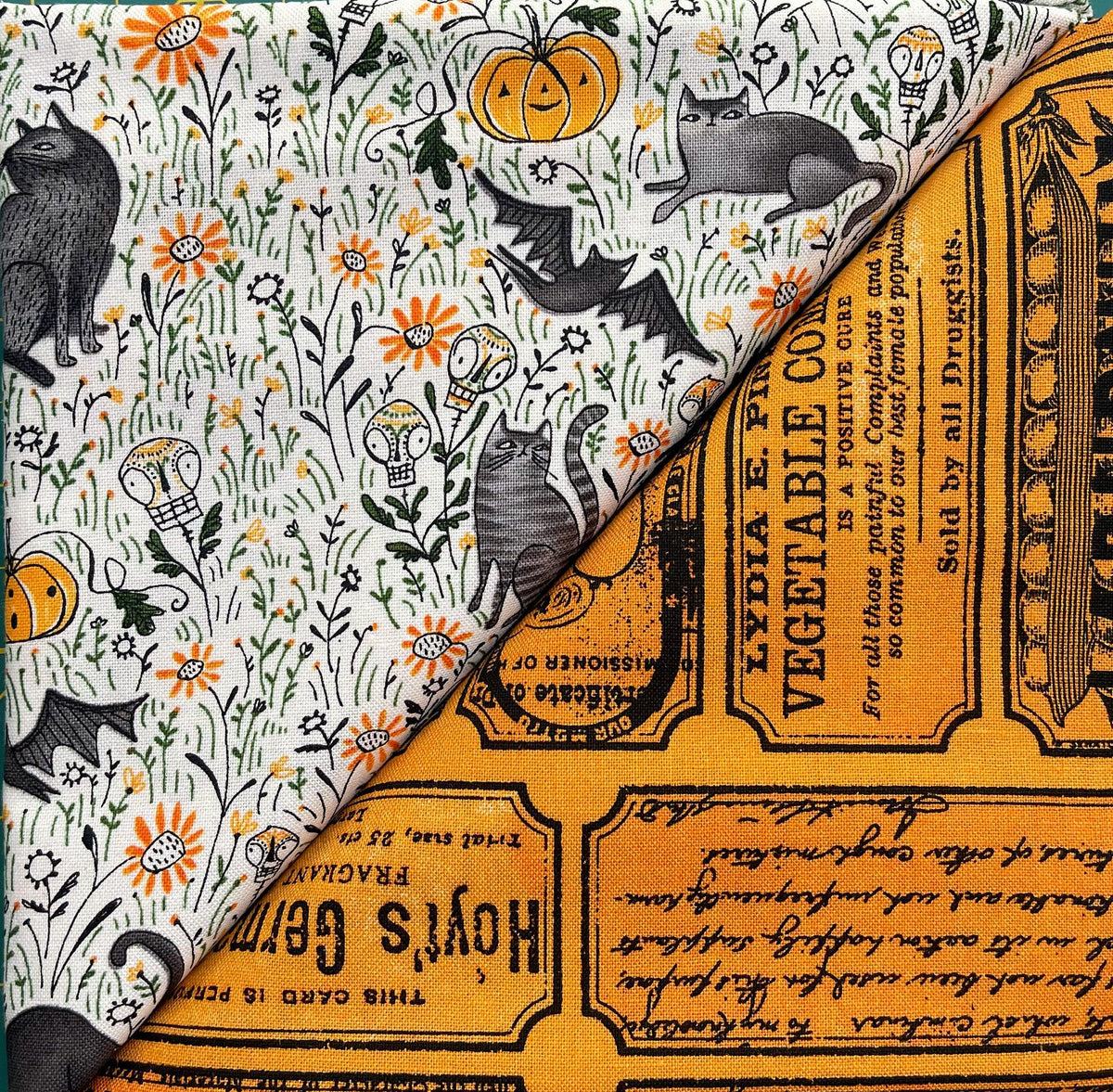 Halloween table runner with white fabric, gray cats, and orange ticket-style text panels