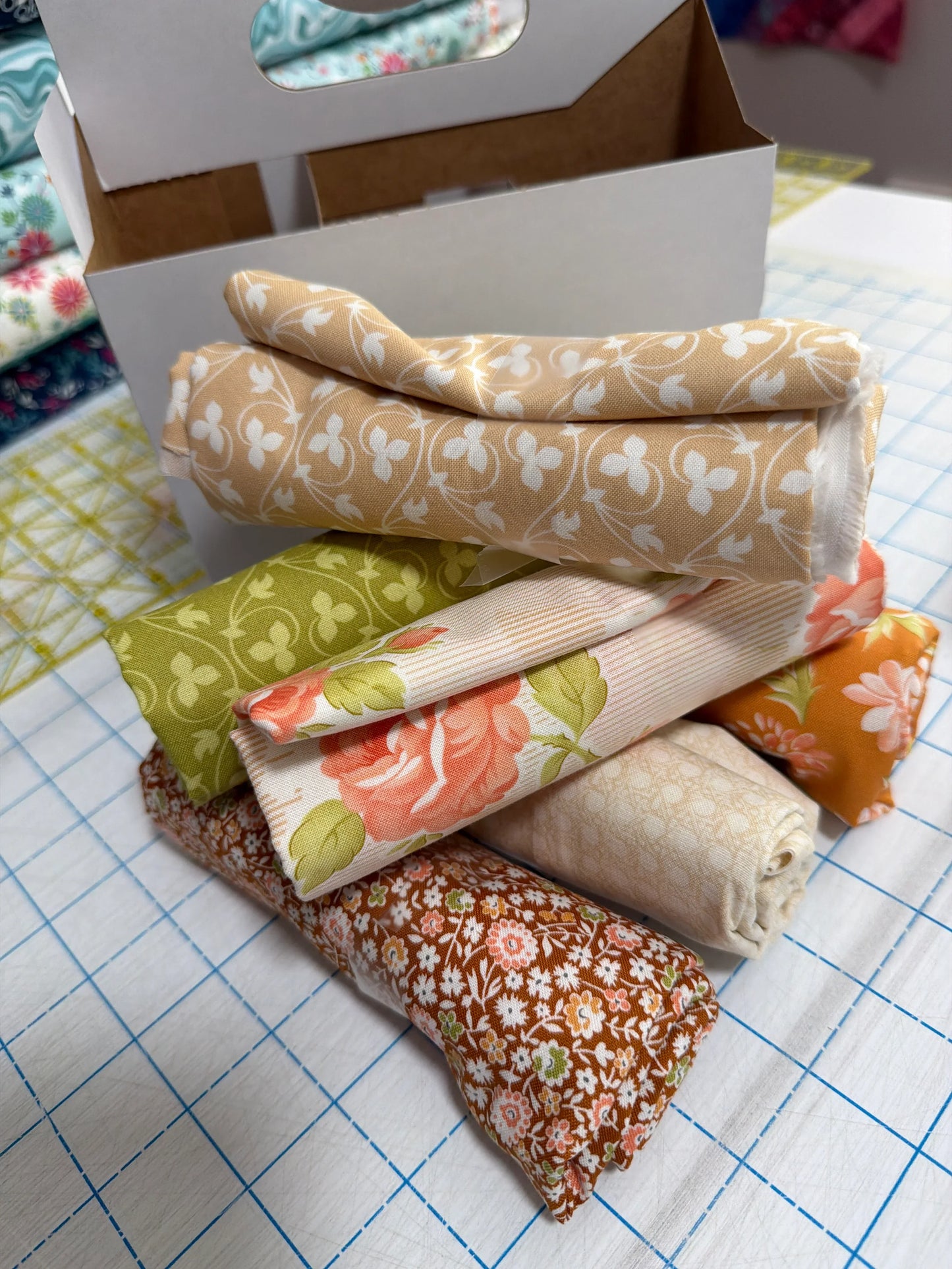 Quilt fabric bundle, folded pieces in cream, green, orange floral and striped