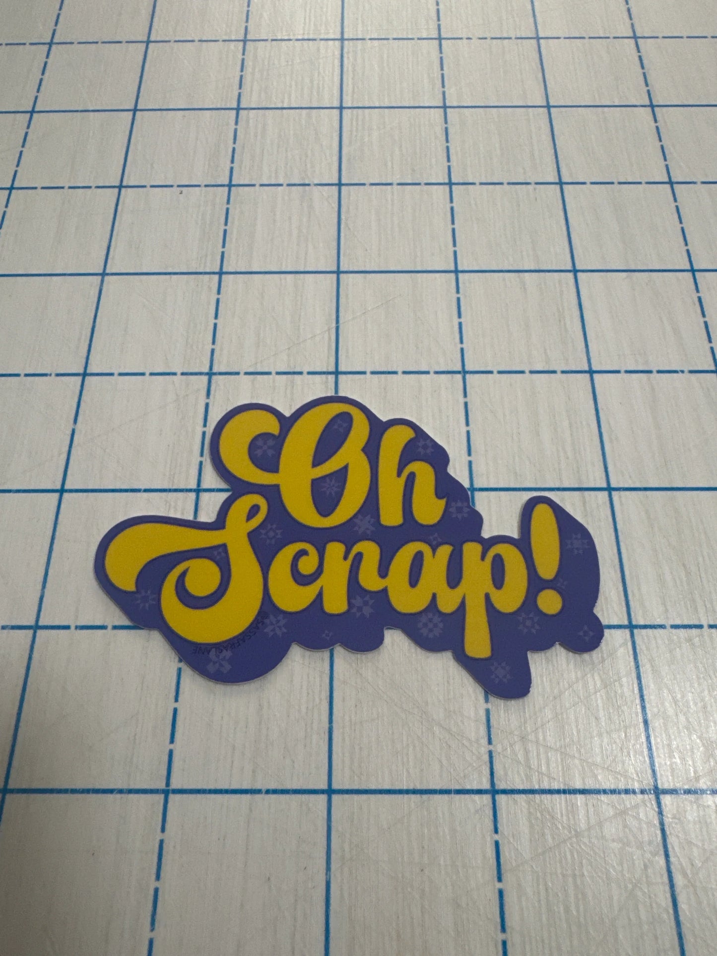 Oh Scrap! sticker, dark blue with gold lettering, cutout shape