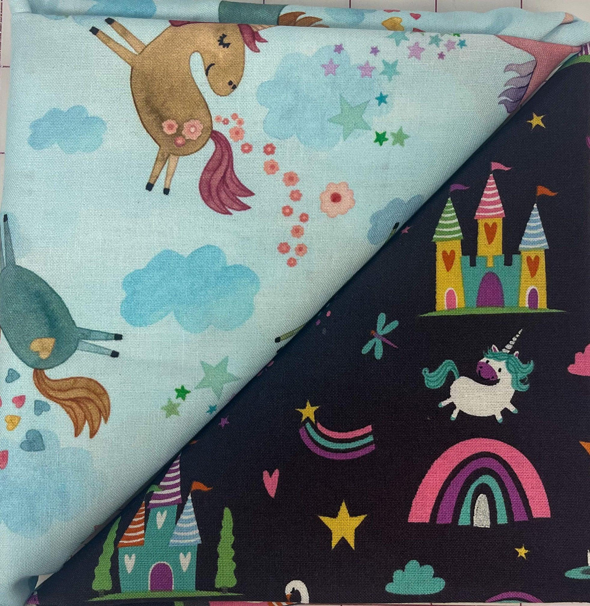 Table runner fabric with unicorns, rainbows, stars and castles; light blue and dark navy