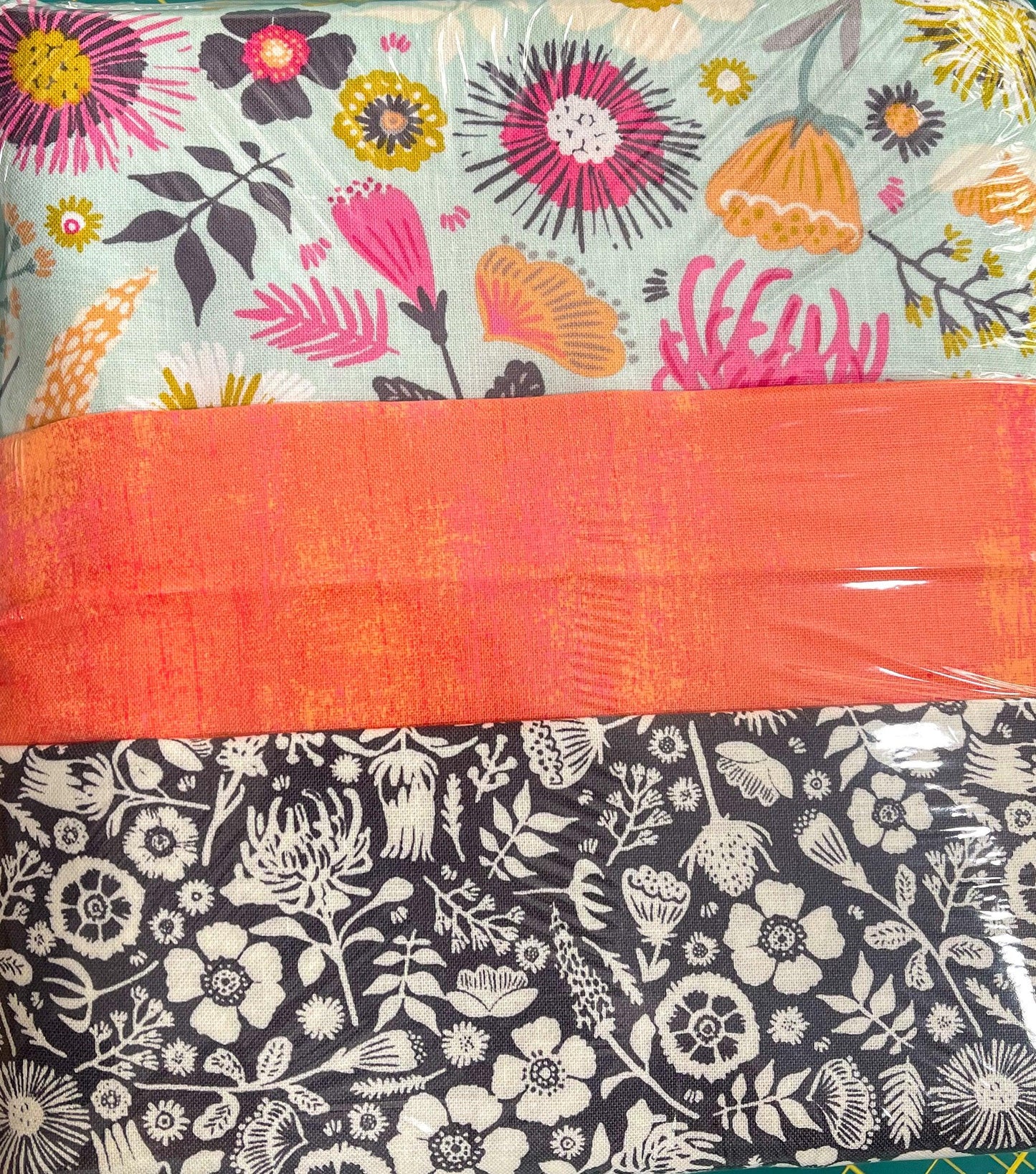 Quilt bundle fabric pieces with floral prints, dark navy botanical and orange panel