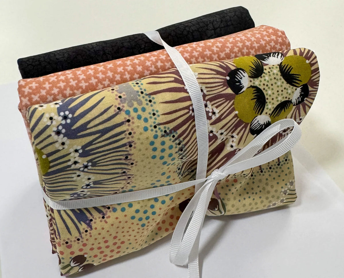 Ecru quilt bundle with animal and star prints, tied with white ribbon