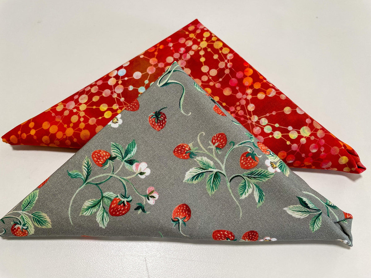 Strawberry table runner with gray fabric and red berry floral print, folded for display