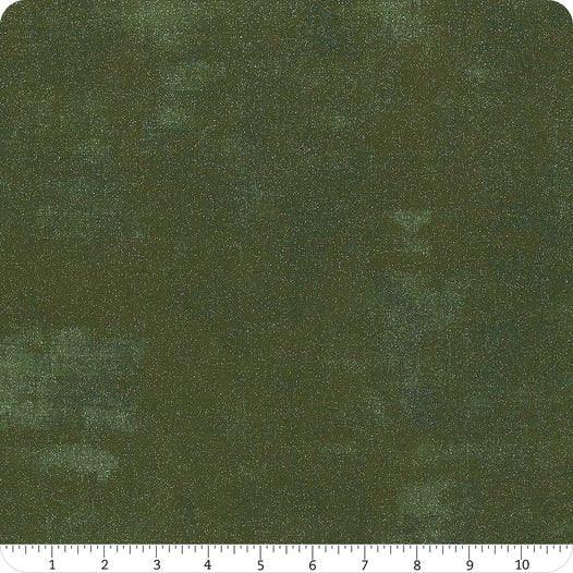 Green glitter fabric yardage with speckled texture; visible ruler scale