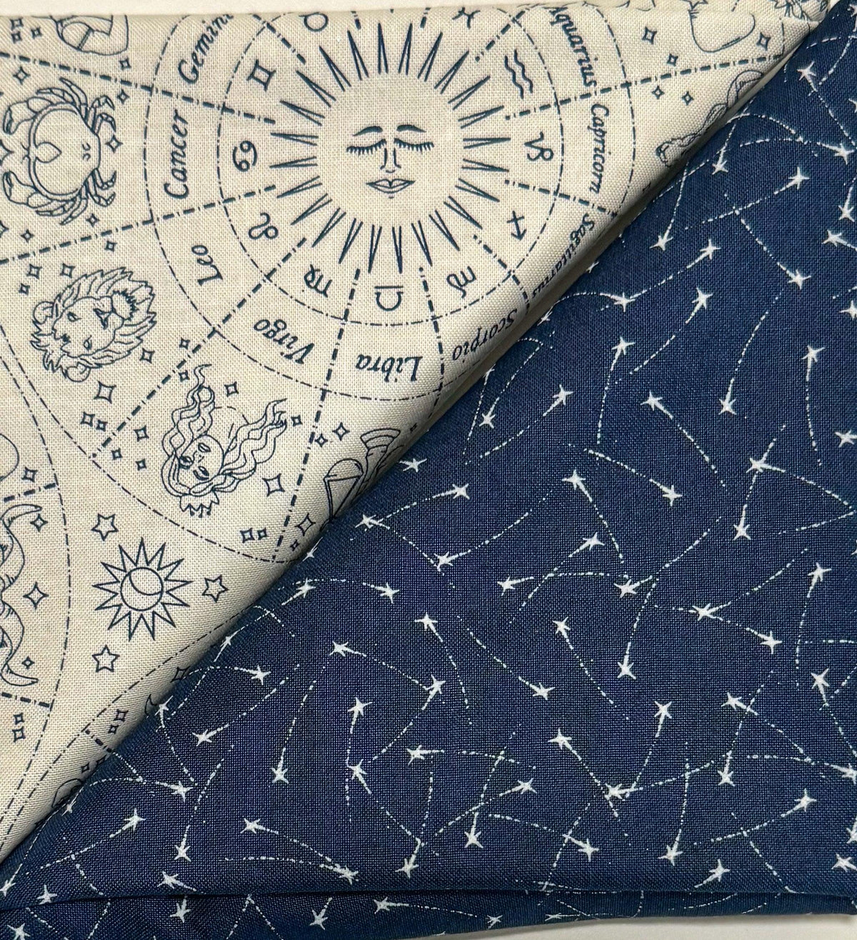 Blue table runner fabric with white shooting-star lines and seam, paired with cream zodiac print edge