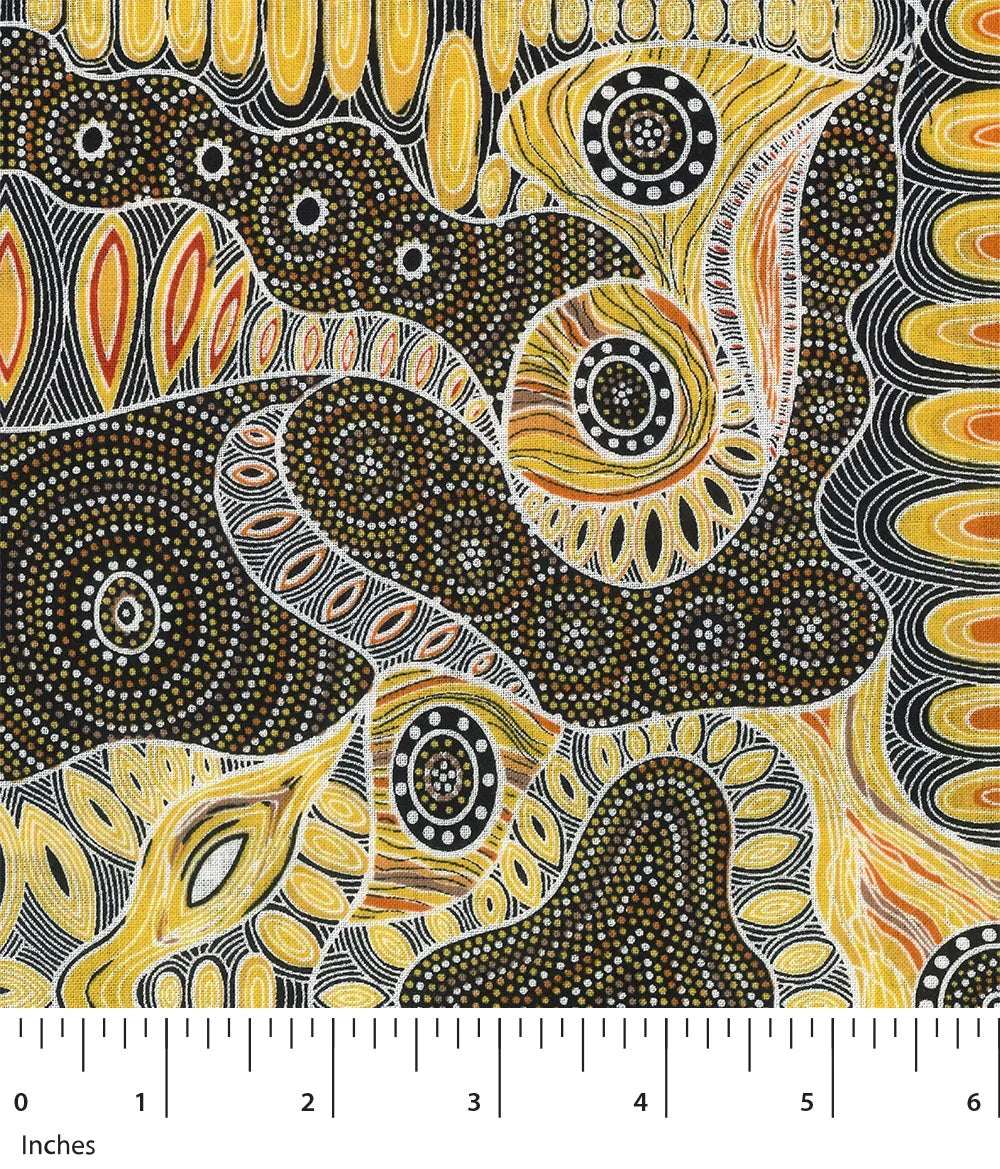 Printed fabric swatch with yellow, black, and white dot and swirl motifs; inches scale