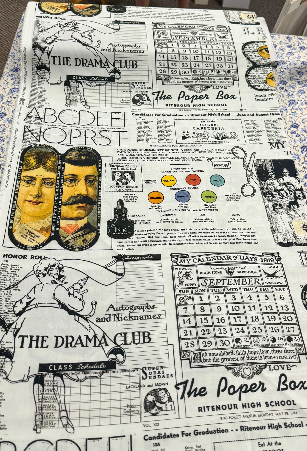 White printed fabric with school collage print, faces, “Drama Club” text, and calendars.