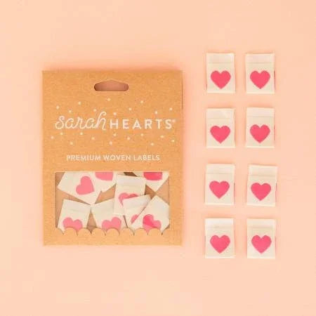 Pink woven label set with red heart icons, includes multiple small labels