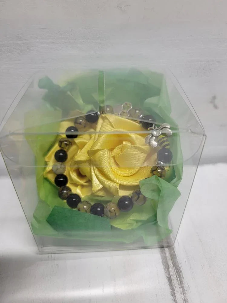Beaded bracelet in clear gift box with green filler and yellow rose decoration