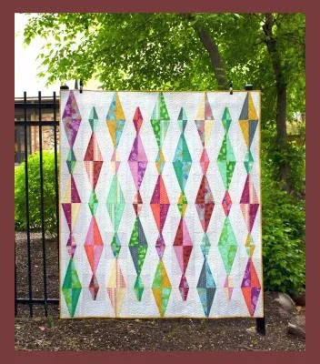 Quilt sewing pattern design shown on a full quilt with multicolor diamond blocks