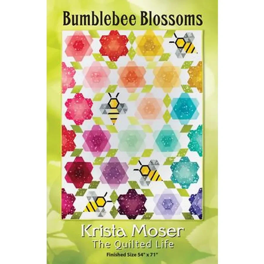 Quilt kit box close-up showing multicolor floral geometric blocks with honeycomb motifs