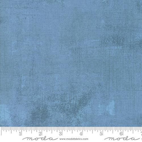 Faded blue denim fabric swatch with subtle distressed texture
