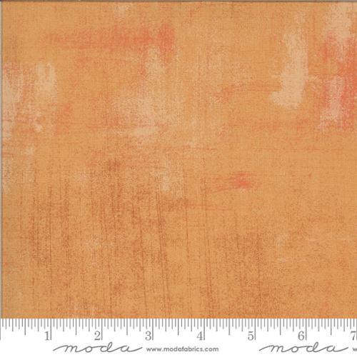 Grunge printed fabric swatch in tan and orange with distressed pattern