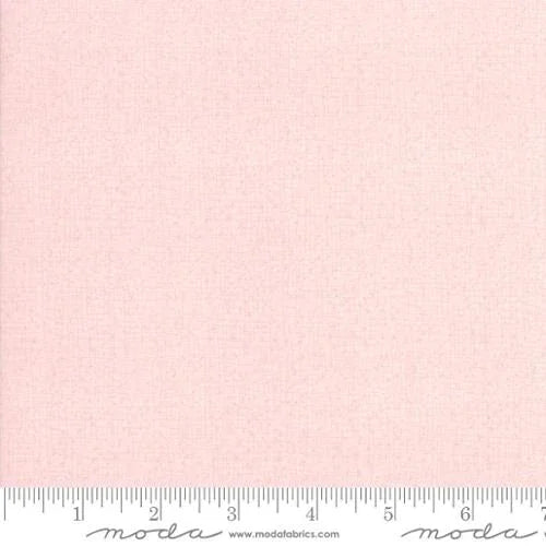 Light pink cotton quilting fabric with repeating small pattern