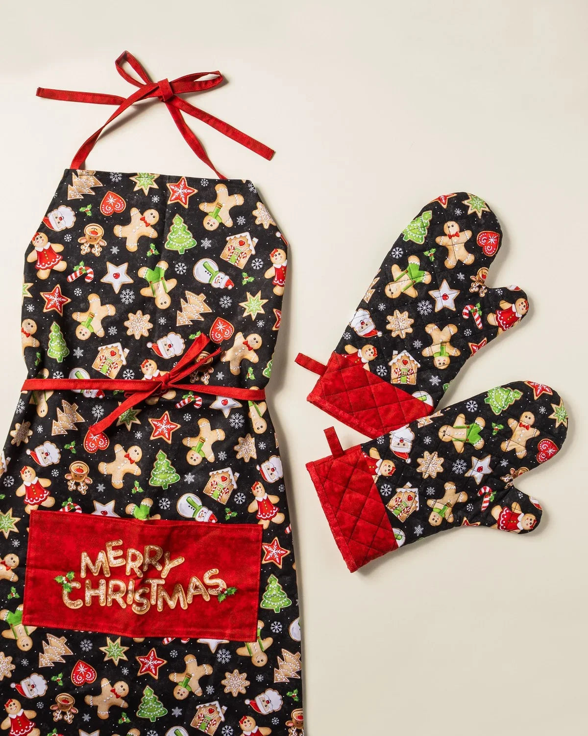 Christmas apron and oven mitts set in dark fabric with red ties; gingerbread and star print