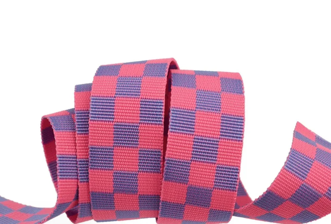 Checkered ribbon webbing in pink and navy with coral squares, folded