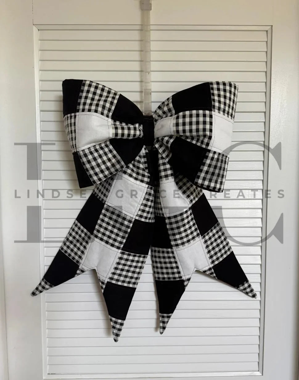 Oversized quilted bow in black and white check fabric with angled pointed tails