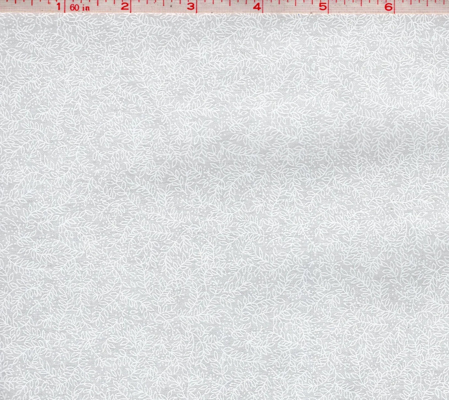White fabric with subtle white vine pattern, close-up texture