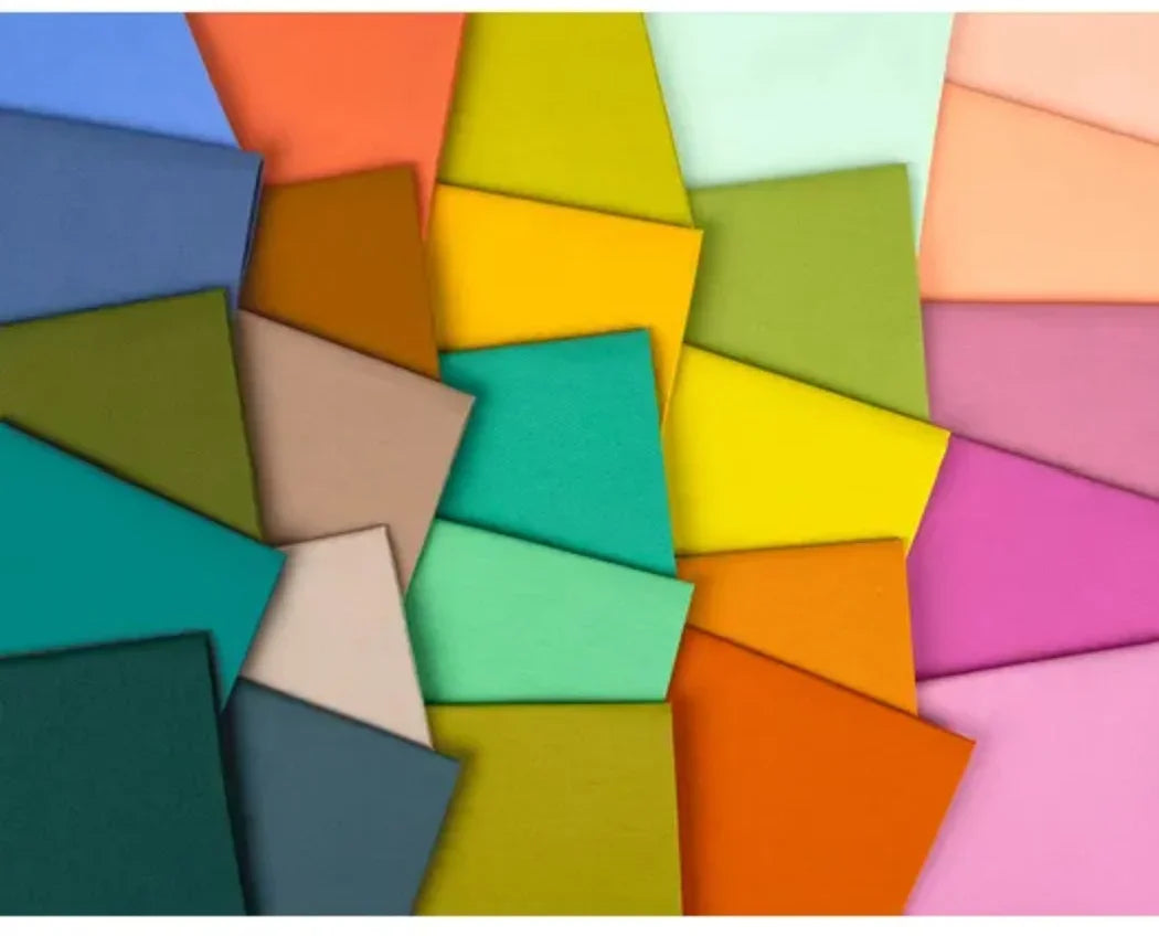 Assorted colorful fabric precut 2.5-inch squares stacked in mixed blocks