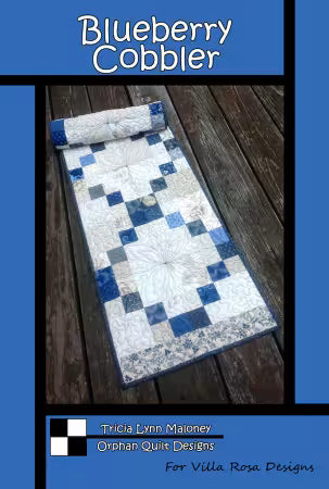 Blueberry Cobbler quilt pattern featuring a blue, white, and gray patchwork table runner.
