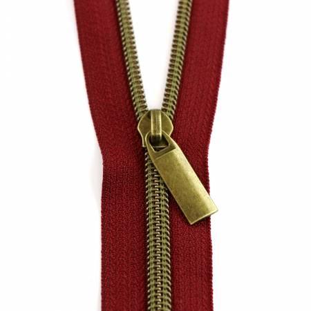 Burgundy nylon coil zipper with antique brass metal pull and double teeth