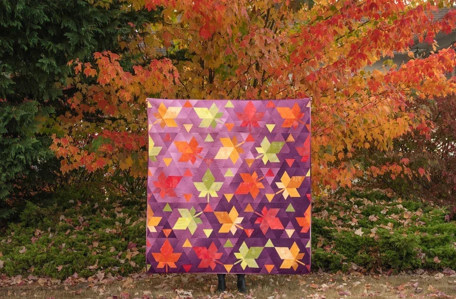 Multicolor fall-themed quilt with geometric triangle blocks
