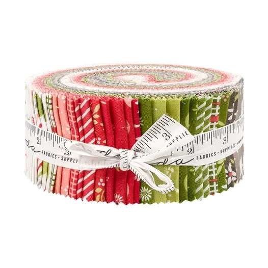 Christmas jelly roll fabric bundle rolled and tied with red and green prints