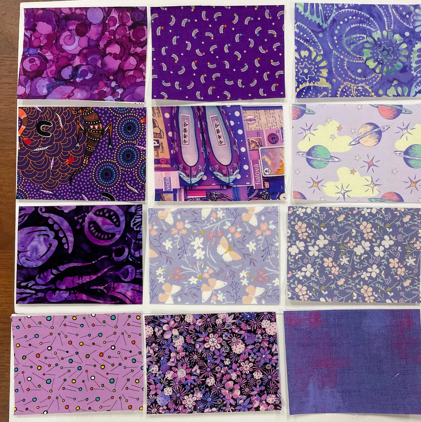 Purple fabric palette packet with multiple patterned cotton squares, assorted designs