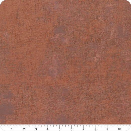 Textured cotton fabric yardage in dark rust brown with speckled pattern