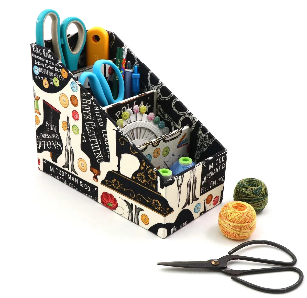 Black fabric caddy organizer with colorful compartments holding scissors, yarn, and craft tools