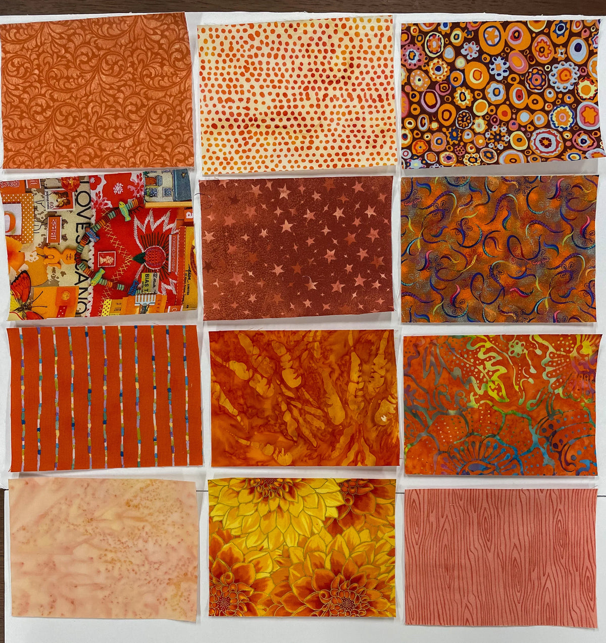 Orange fabric patchwork squares assortment, various prints and stripes in warm tones