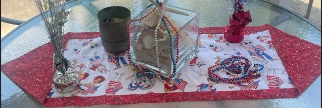 Holiday table runner with red, white, and blue printed snowy design