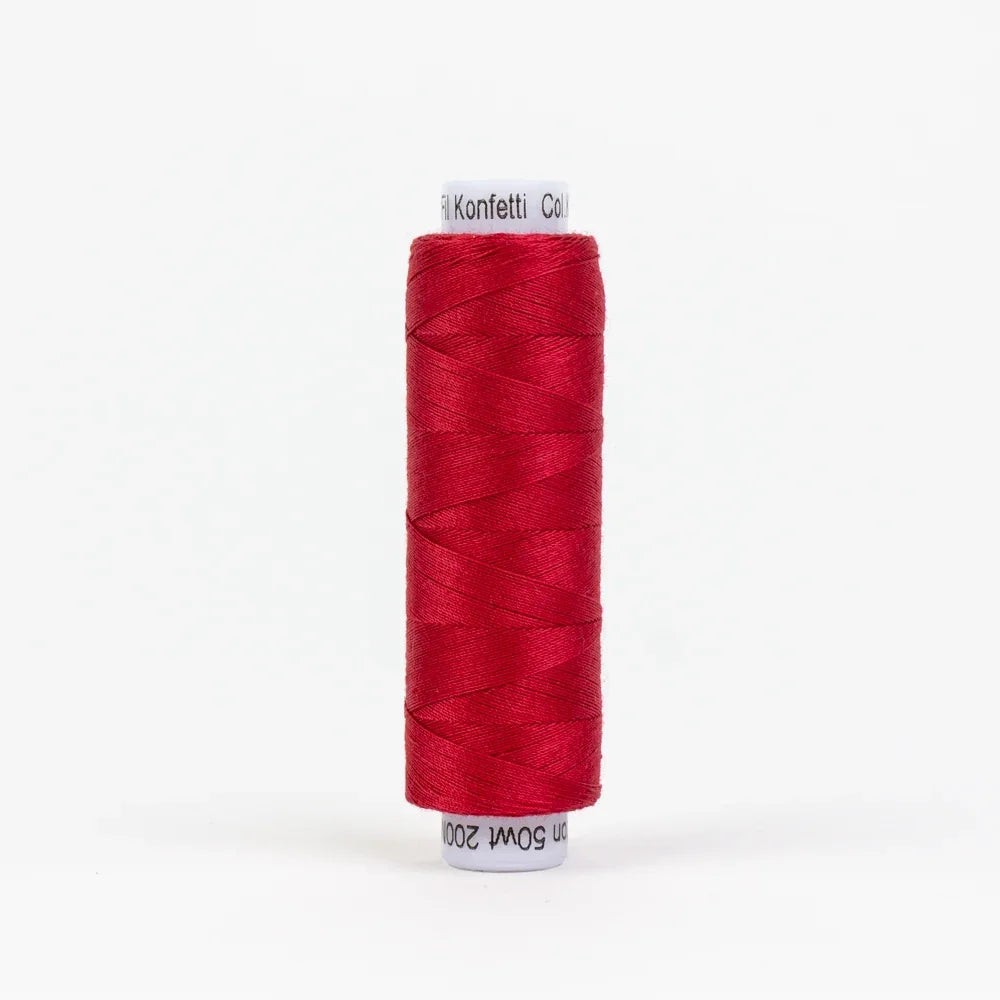 Red sewing thread spool, wound on white cardboard core